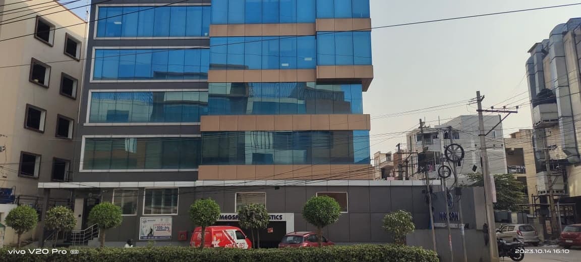 MEGSAN Diagnostics commercial building with blue glass curtain wall and bronze cladding accents